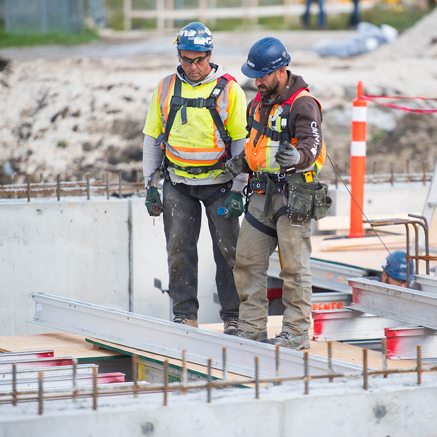 Workers in PPE talking on site