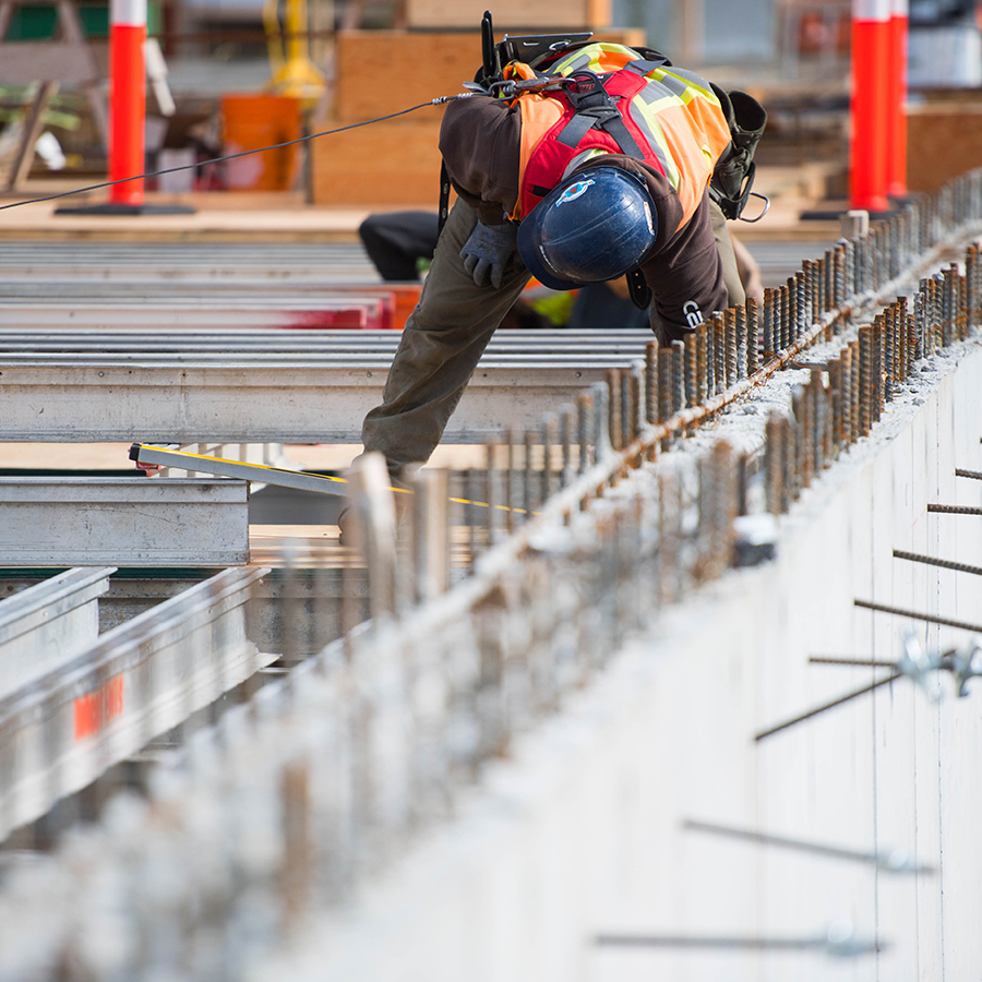 construction worker measuring steel roof