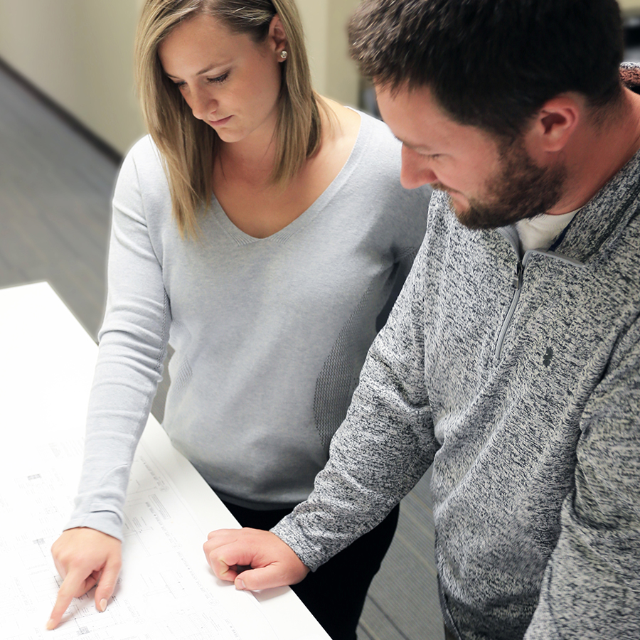 two employees viewing architect drawing