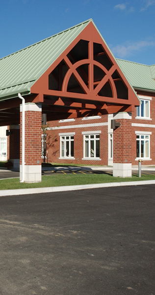 Brick Columned Porte-Cochere and Green Steel Peaked Roof