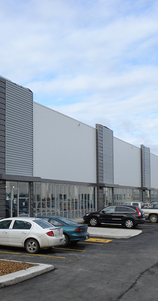 Glass and Panel Facade with Parking Spaces and Vehicles