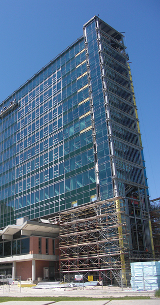 Construction Progress of Curtain Wall Installation Above Existing Building with Scaffolding