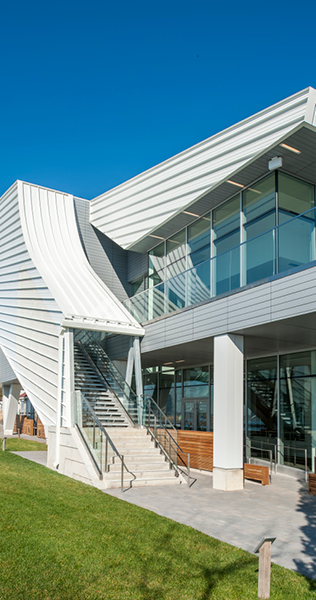 Close up exterior view of staircase with white cladding leading up to glass enclosed first floor