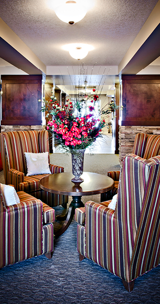 Four Armchairs Encircling a Coffee Table With Vase and Floral Bouquet