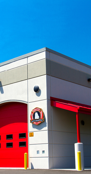 Stucco Facade Corner with Bright Red Overhead Door and Awning