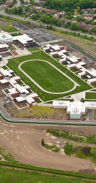Aerial View of Compound Buildings Surrounding an Athletics Field with Running Track