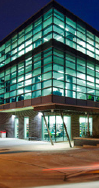 Illuminated Glazed Facade Corner Against a Night Sky