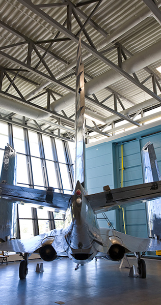 Fighter Jet Positioned In Front of Glazed Wall