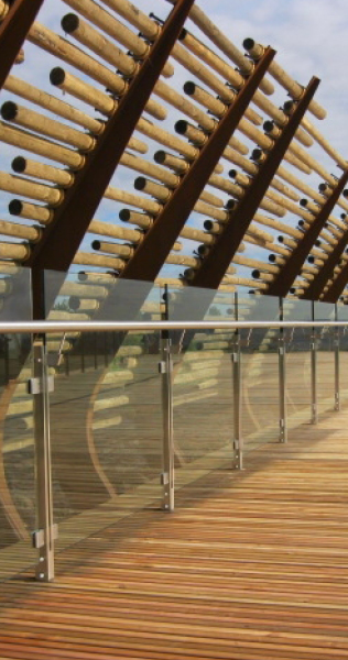 Wooden walkway with glass panel railing and log windbreak