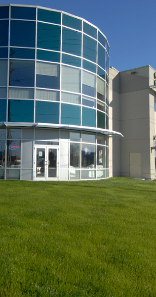 Exterior view of Michael-Angelos Market Place showing curved edge of building and lawn