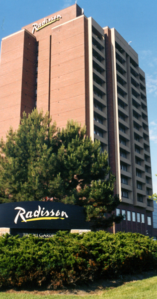 Exterior view of Radisson Suites Hotel building showing some landscaping