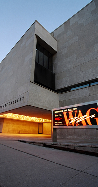 Exterior view of lit entrance to Winnipeg Art Gallery and partial view of backlit billboard