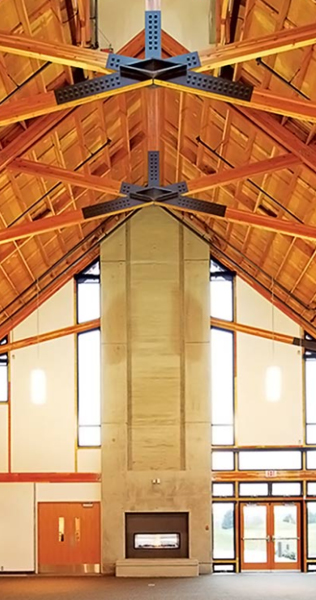 Interior of the Riverway Golf Clubhouse showing vaulted wood ceilings and dramatic stone fireplace