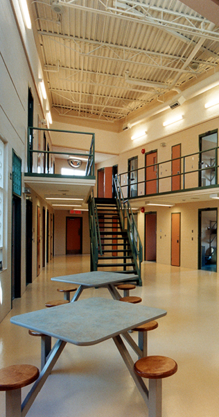 Common Atrium with Table and Stools with Cell Doors in the Background