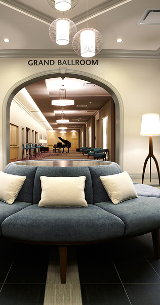 Circular Upholstered Bench in the Foreground with an Arched Entrance Way to the Grand Ballroom in the Background