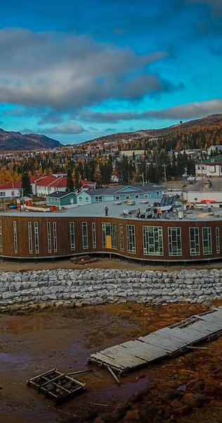 Community Centre with Dry Seabed in Font and Houses Receding to Mountains in the Back