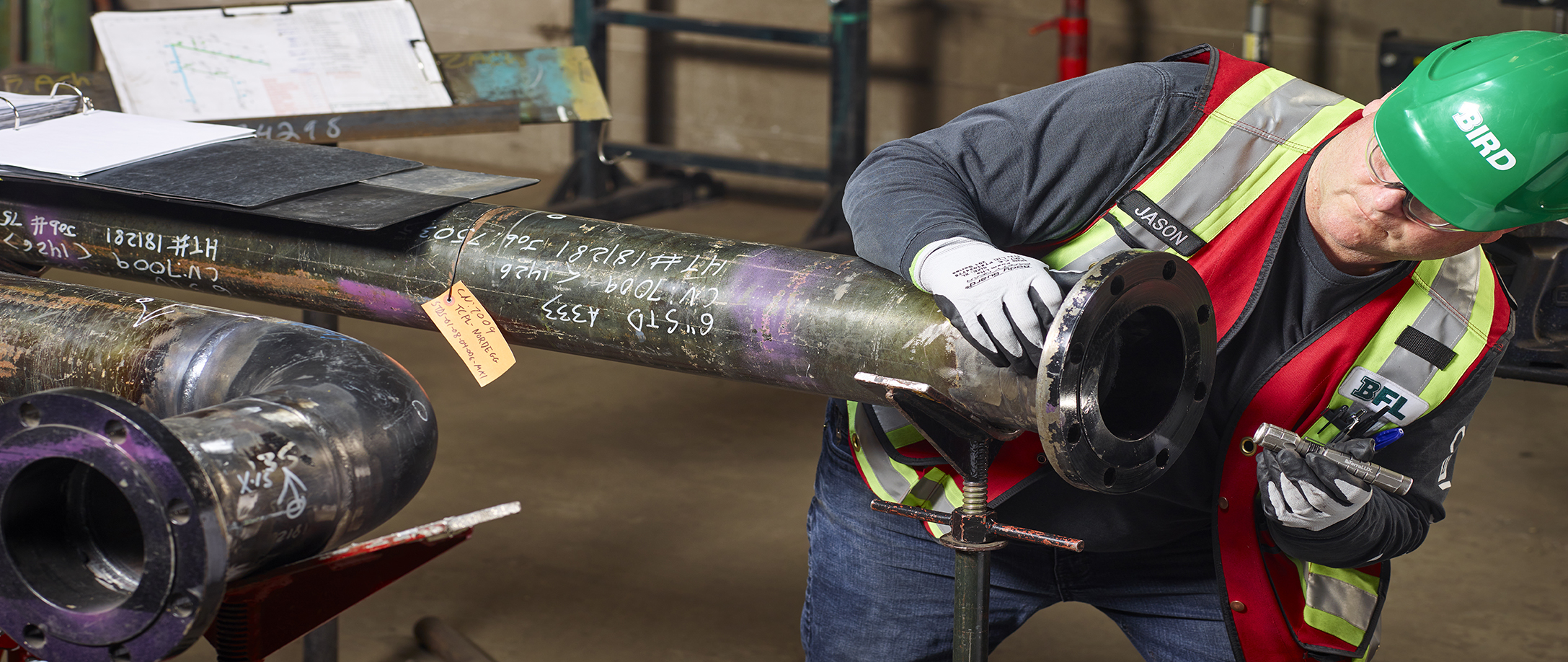 Bird employee inspecting a pipe