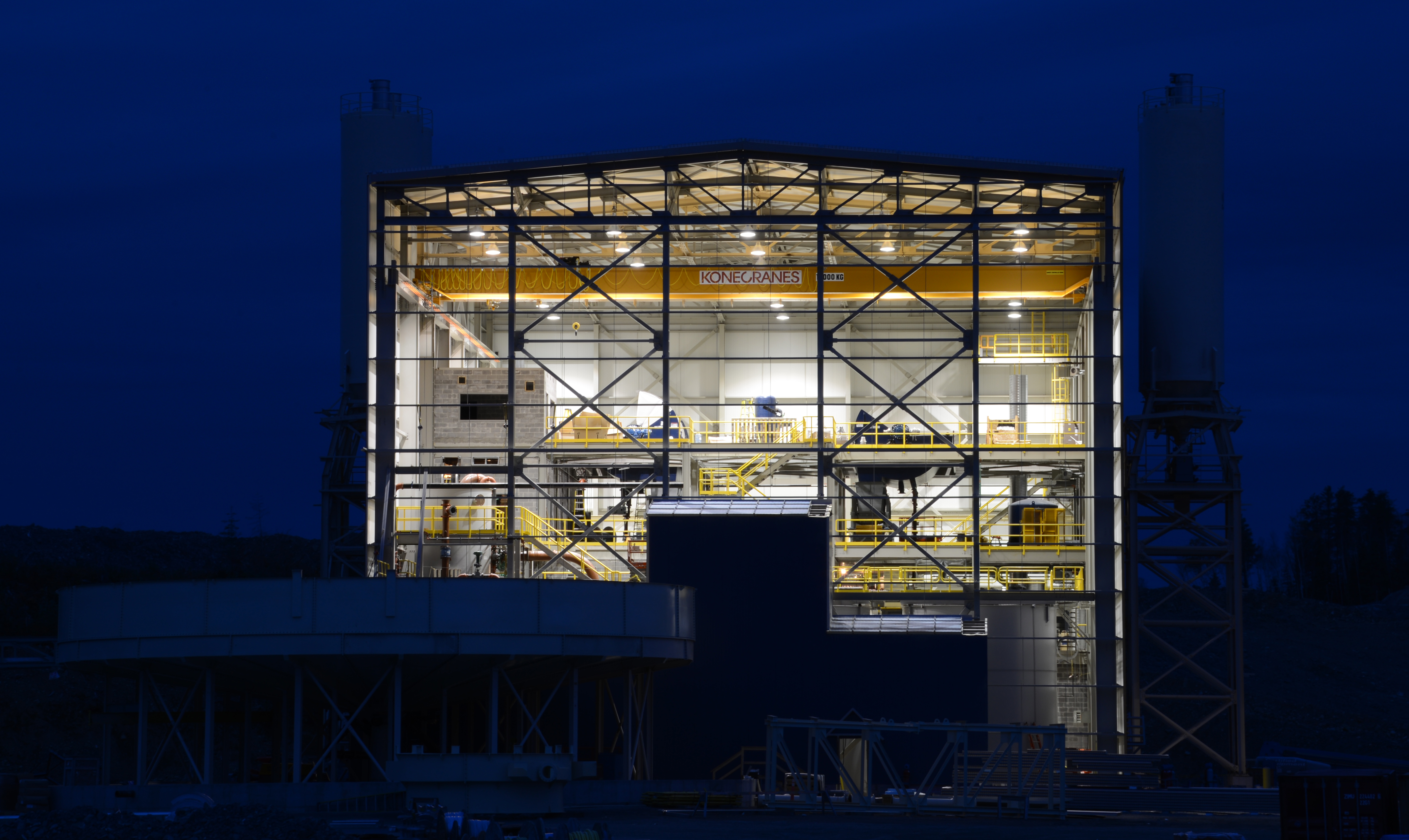 Exterior of gold mine lit up at night highlighting interior floors of building