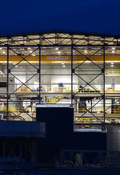 Exterior of gold mine lit up at night highlighting interior floors of building