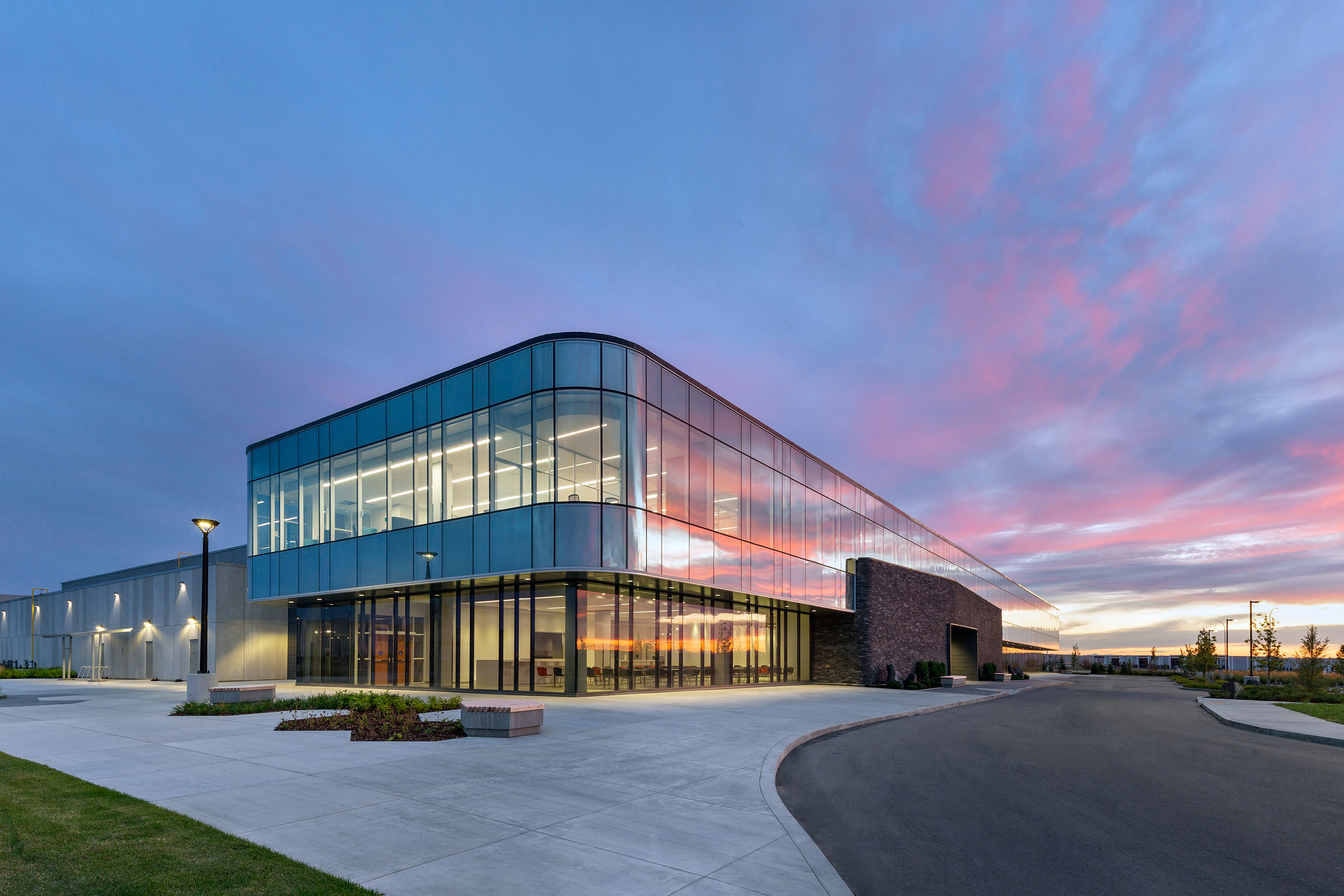 Exterior of curved glass building at sunset