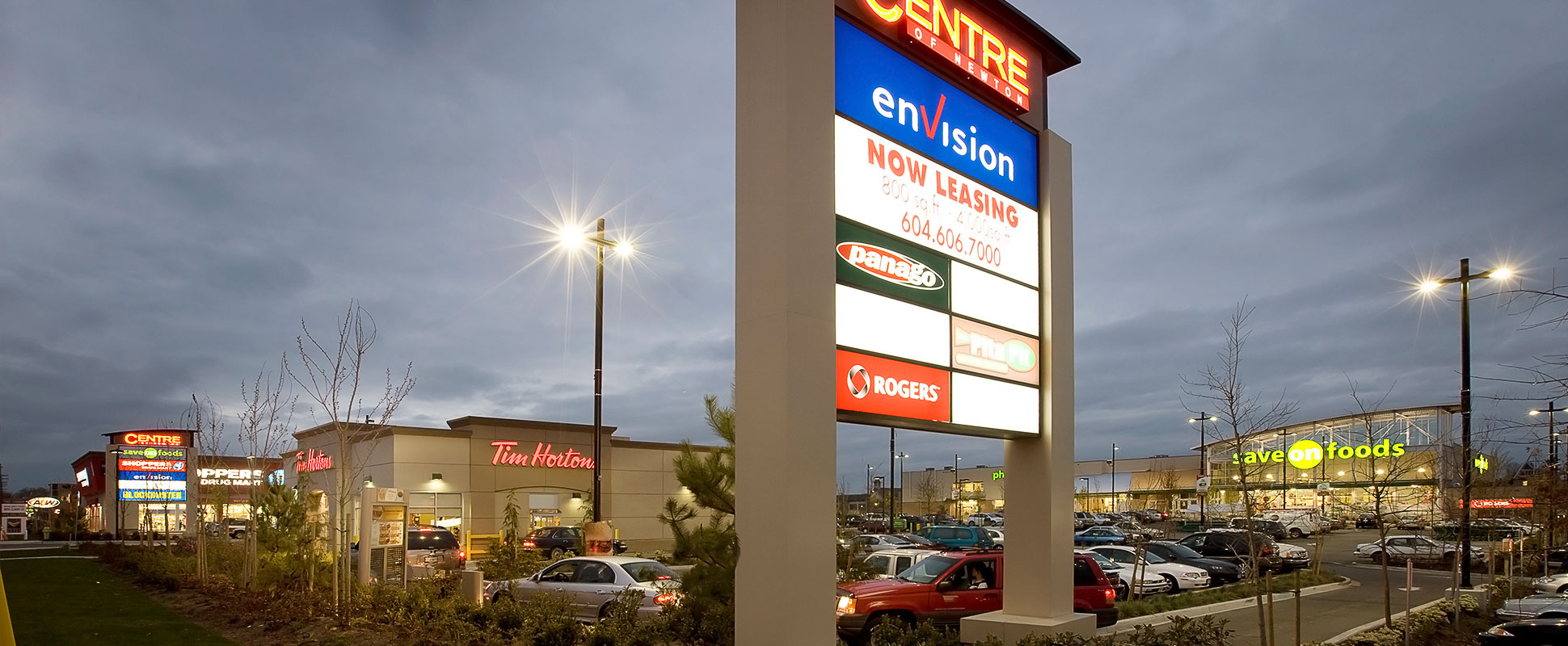 Centre of Newton lit at night showing retail store signage