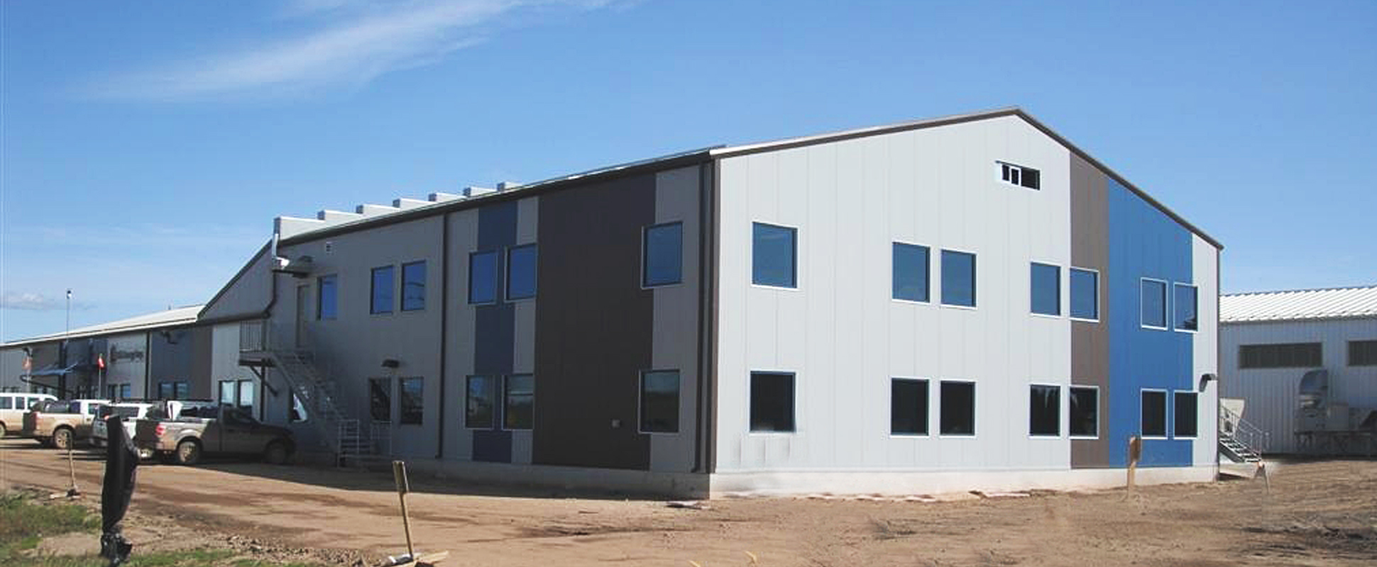 MEG Energy Maintenance and Administration Building exterior showing white, blue and grey cladding 