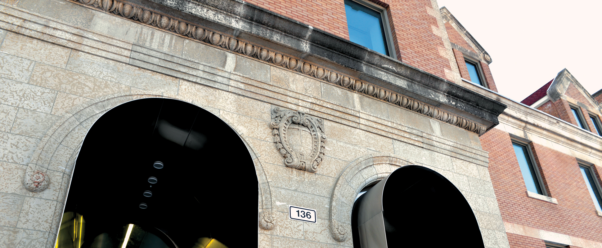 Close up of the Taché Hall Music, Art and Theatre Complex exterior showing stone details above arches