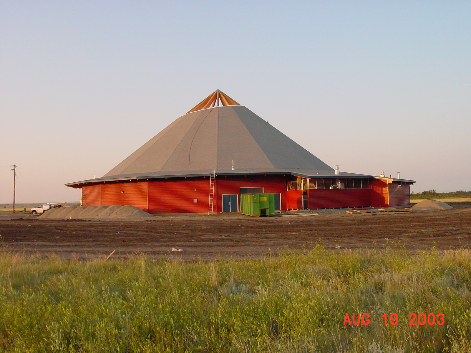 Red circular building on a field